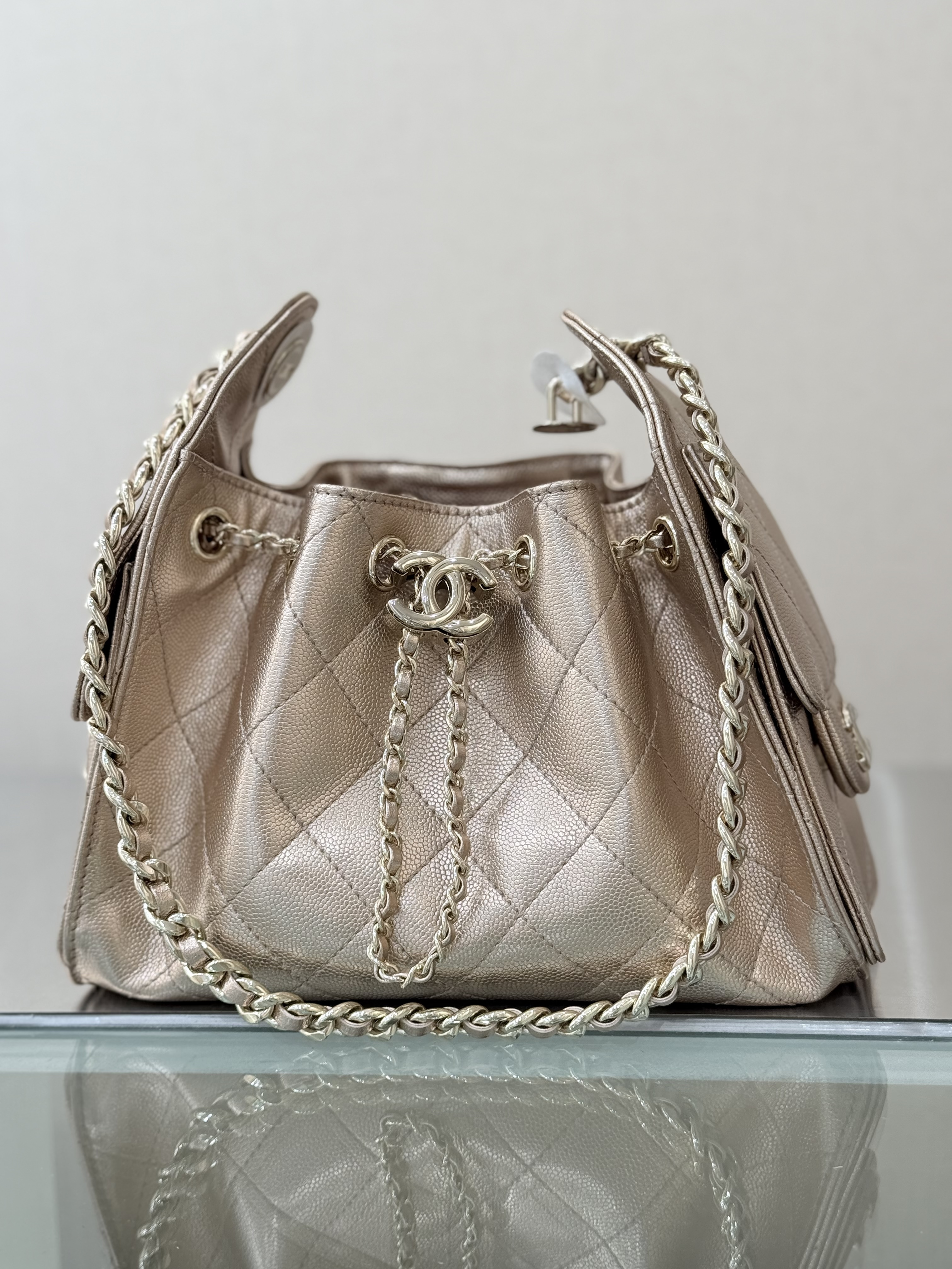 Spring-Summer 2025 Rose Gold Metallic Quilted Grained Calfskin Drawstring Bucket Bag with Gold-Tone Hardware