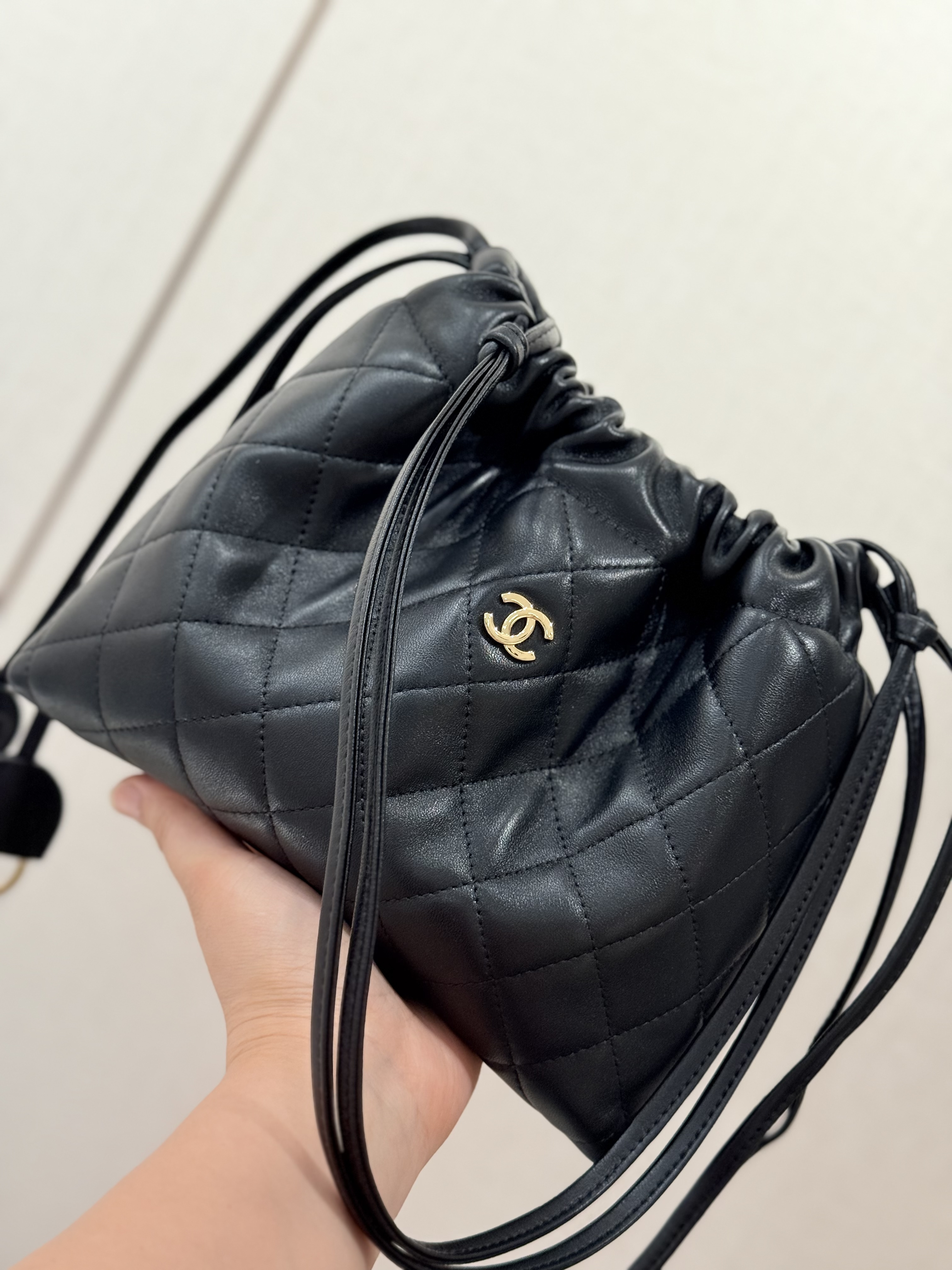 Spring-Summer 2026 Black Quilted Lambskin Mini Drawstring Bucket Bag with Gold-Tone CC Logo